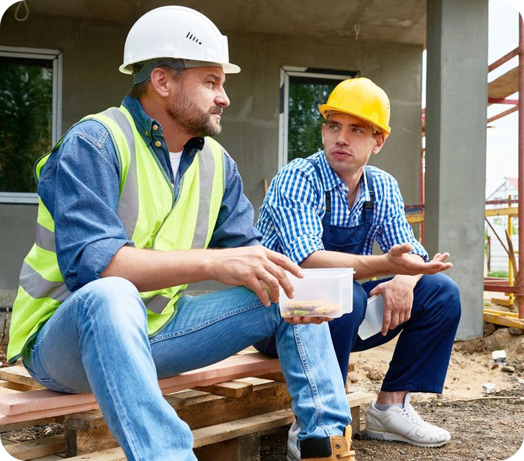 Two construction workers sitting on a platform