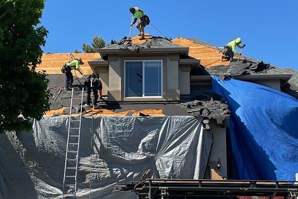 A group of men working on the roof of a house.