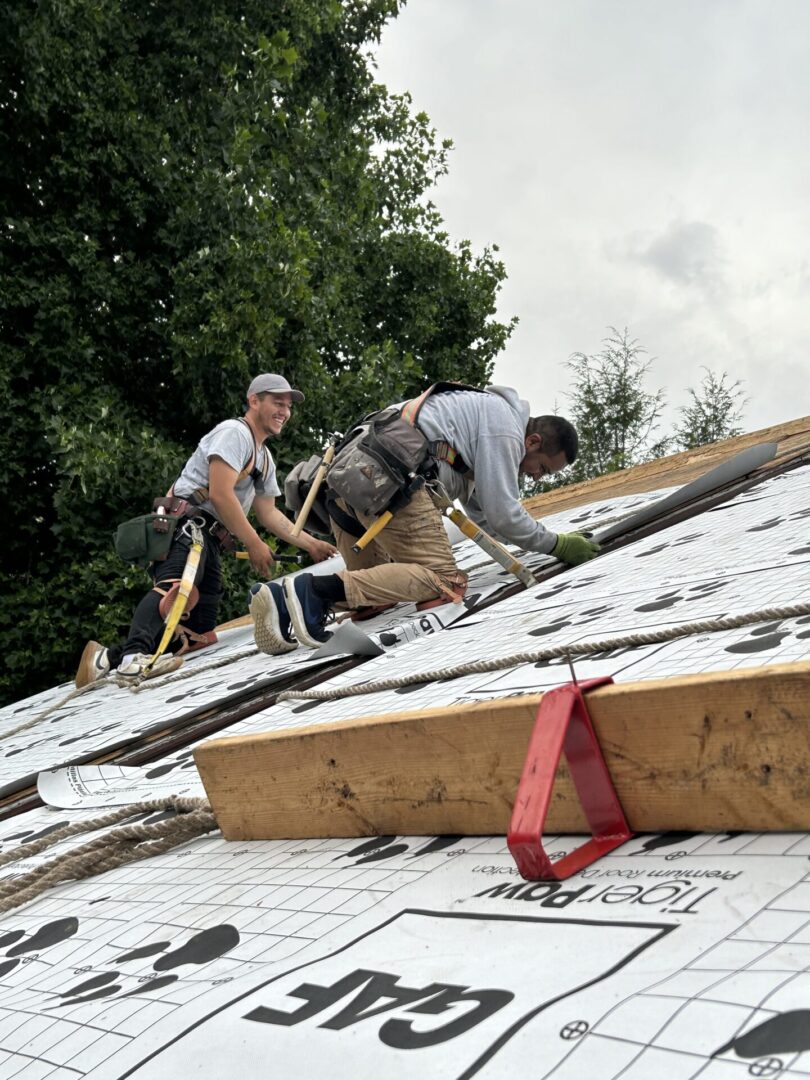 A group of men working on the roof of a house.