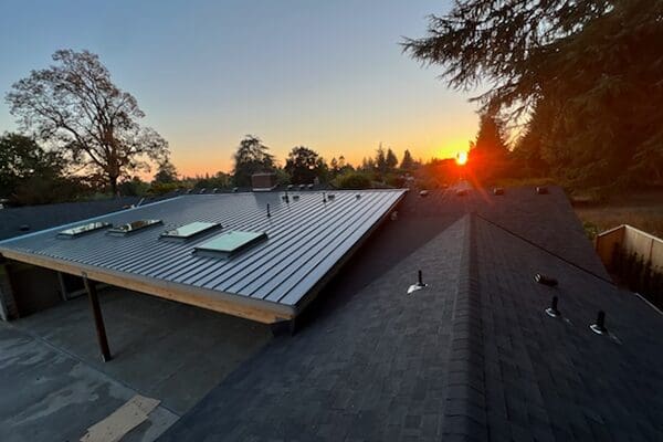 A view of the sun setting over a building.