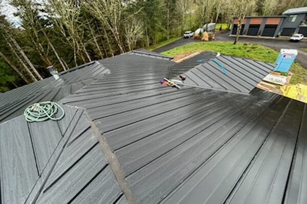 A metal roof being installed on top of a house.